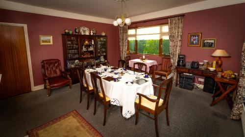 基爾肯尼的住宿－Cradog B&B.，一间配备有白色桌椅的用餐室