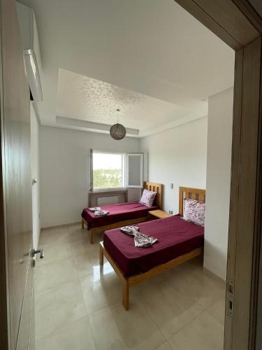 a bedroom with two beds and a window at Maison de vacances in Hammamet Sud