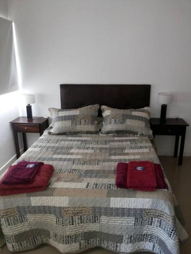 a bed with two pillows on it with two tables at San Isidro in Viedma