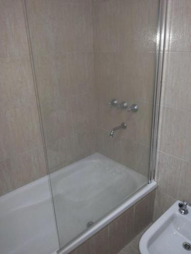 a shower with a glass door next to a sink at San Isidro in Viedma