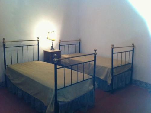 two twin beds in a room with a lamp at Casa da Lagoa in Évora