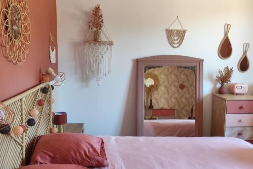 une chambre avec un lit et un miroir dans l'établissement Gîte Le chant des mésanges 07260 Vernon, à Vernon
