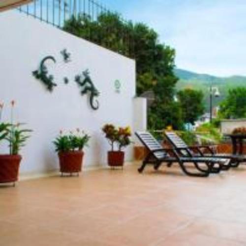 a balcony with benches and a bike on a wall at Hotel Plaza Versalles in Cali