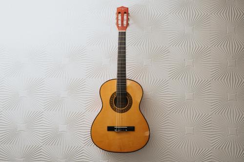 a guitar is hanging on a wall at Majestic Gem - Pool Table - Coop - Etihad - Parking in Manchester
