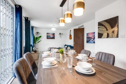 a dining room with a wooden table and chairs at Majestic Gem - Pool Table - Coop - Etihad - Parking in Manchester
