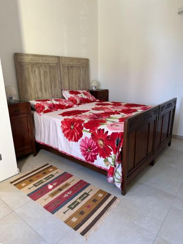 a bedroom with a bed with a red floral bedspread at La Casetta in Varese Ligure