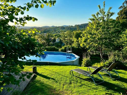 um quintal com duas cadeiras e uma piscina em Casa da Fontiña em Tortoreos