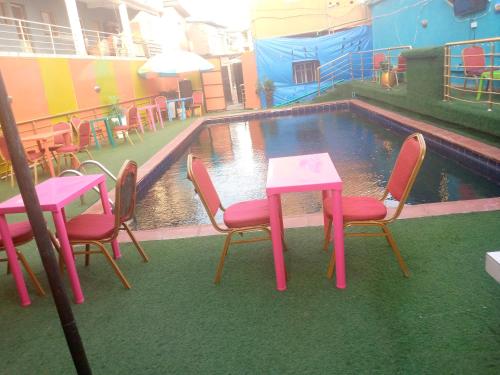 D'Island Hotel and Club في ليكى: طاوله وكراسي امام مسبح