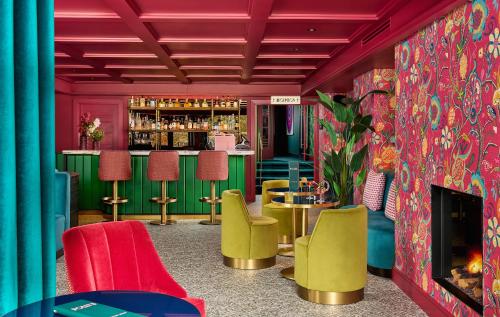 a bar with colorful chairs and a fireplace at The Ross in Killarney