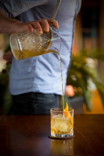 a person pouring a drink from a bottle into a glass at The Ross in Killarney