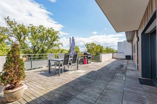 een patio met een tafel en stoelen op een balkon bij Beautiful T3 with large terrace - Anglet - Welkeys in Anglet