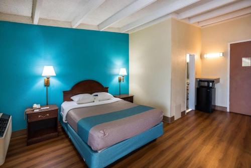una camera con letto e parete blu di Red Carpet Inn & Suites a Philadelphia