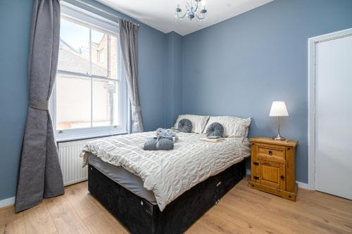 倫敦的住宿－SIDNEY，一间卧室配有一张蓝色墙壁的床和一扇窗户