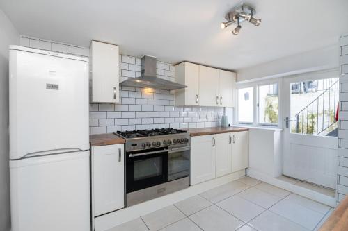 a kitchen with white appliances and white cabinets at SIDNEY in London