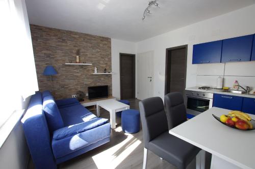 sala de estar con sofá azul y cocina en Apartments Branko, en Selce