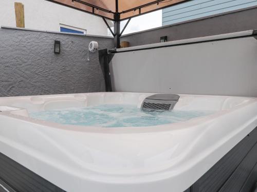 a bath tub with a laptop sitting in it at Clydfan, No 1 Trearddur Road in Trearddur