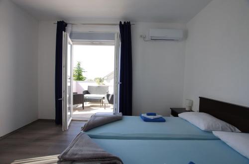 1 dormitorio con 1 cama y puerta que da a un patio en Apartments Branko, en Selce