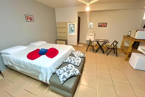 VA Apart Hotel Savassi في ديفينوبوليس: غرفة نوم مع سرير عليها قوس احمر