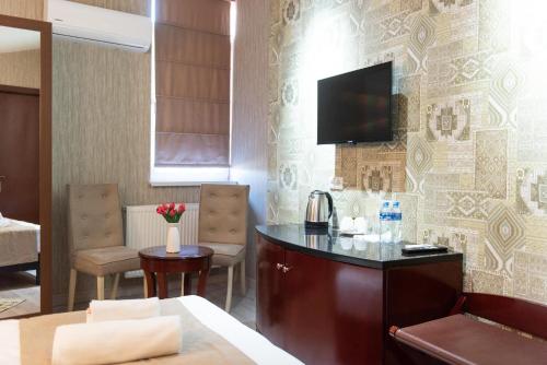 a hotel room with a desk and a tv on a wall at Kraveli Hotel in Tbilisi City