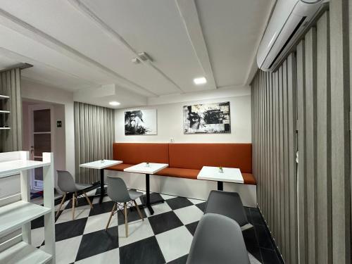 a meeting room with desks and chairs and a checkered floor at Vila Storia in Niš