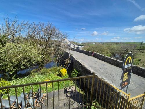 a bridge over a river with a sign on it at River View Apart Doolin in Doolin