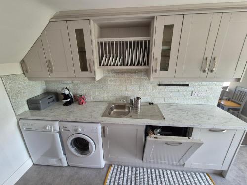 a kitchen with a sink and a washing machine at River View Apart Doolin in Doolin