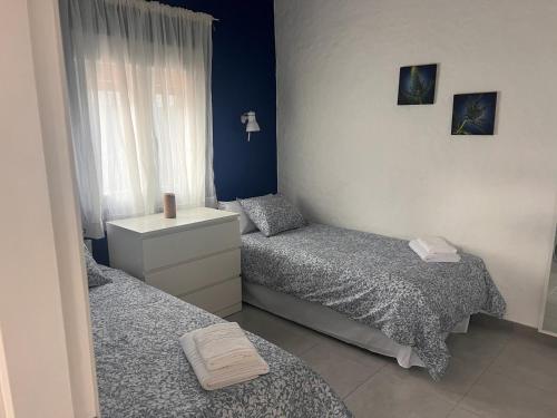 2 Einzelbetten in einem Zimmer mit blauen Wänden in der Unterkunft MAR Y SOL in Maspalomas
