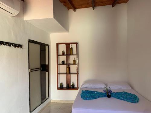 Schlafzimmer mit einem Bett mit blauem Bogen in der Unterkunft Hostal Buena Vida in Taganga
