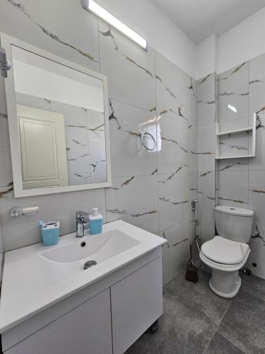 a bathroom with a white sink and a toilet at Sea's Villa in Ksamil