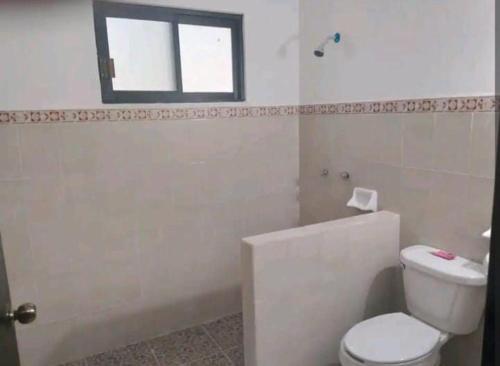 a bathroom with a toilet and a window at Casas Teoli Casita Rosa in Valladolid