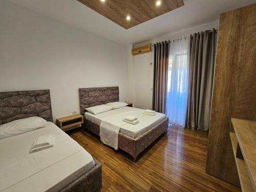 a hotel room with two beds and a window at Sea's Villa in Ksamil