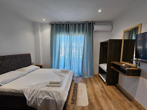 a bedroom with a bed and a large window at Sea's Villa in Ksamil