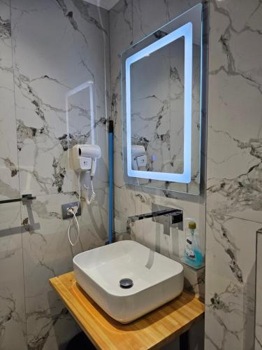 a bathroom with a white sink and a mirror at Sea's Villa in Ksamil