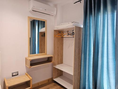a dressing room with a mirror and a blue curtain at Sea's Villa in Ksamil