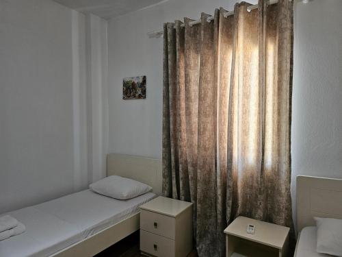 a small room with a bed and a curtain at Sea's Villa in Ksamil