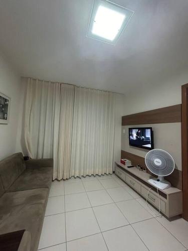 un soggiorno con divano, TV e ventilatore di Apartamento ITAIGARA a Salvador