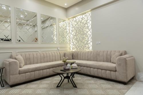 a living room with a large couch and a table at شقة مودرن مقابلة البوليفارد in Riyadh