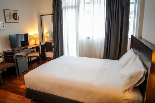 a hotel room with a bed and a desk at Hotel Baeza Monumental by eme hoteles in Baeza