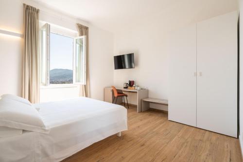 ein weißes Schlafzimmer mit einem Bett und einem Schreibtisch in der Unterkunft Le camere sui colli 2 in La Spezia