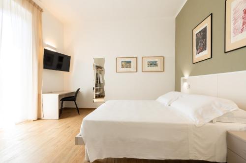 ein weißes Schlafzimmer mit einem weißen Bett und einem Schreibtisch in der Unterkunft Le camere sui colli 2 in La Spezia