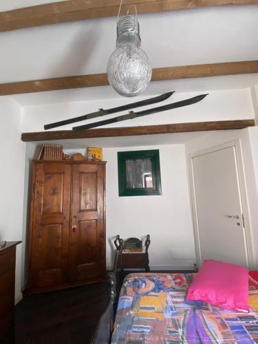 a bedroom with a bed and a wooden cabinet at Via Castello 17 in Bienno