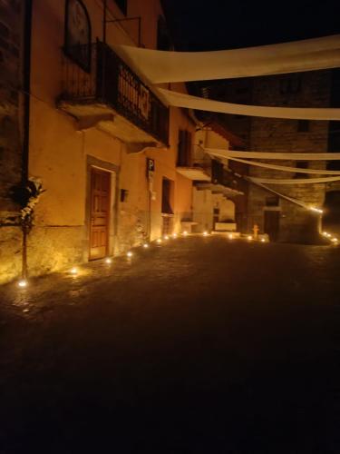 an empty street at night with lights on a building at Via Castello 17 in Bienno