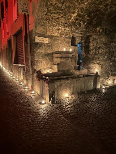 a cat sitting on a street at night with lights at Via Castello 17 in Bienno