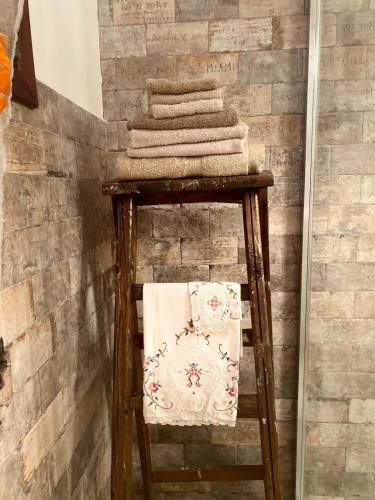 a stack of towels on a stool in a bathroom at Via Castello 17 in Bienno