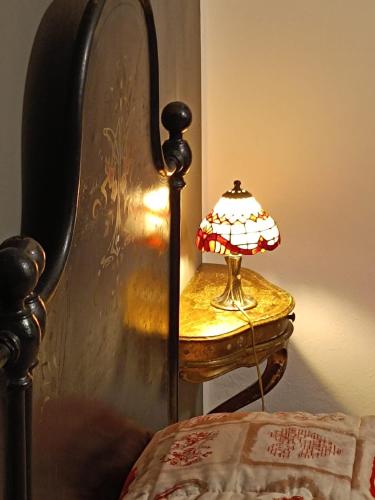 a lamp sitting on a table next to a bed at Via Castello 17 in Bienno