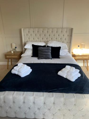 a bedroom with a large bed with towels on it at Chic seaside apartment in Preston