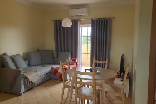a living room with a couch and a table and chairs at Stela ' s Guest House in Loulé