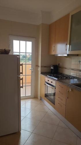 a kitchen with a refrigerator and a stove top oven at Stela ' s Guest House in Loulé