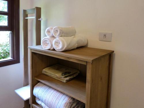 a wooden shelf with rolled towels in a room at Casa do Aconchego in Gonçalves
