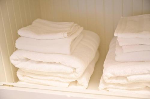 una pila de toallas plegadas en un armario en Quiet UW cottage by Ravenna park-Perfect location en Seattle